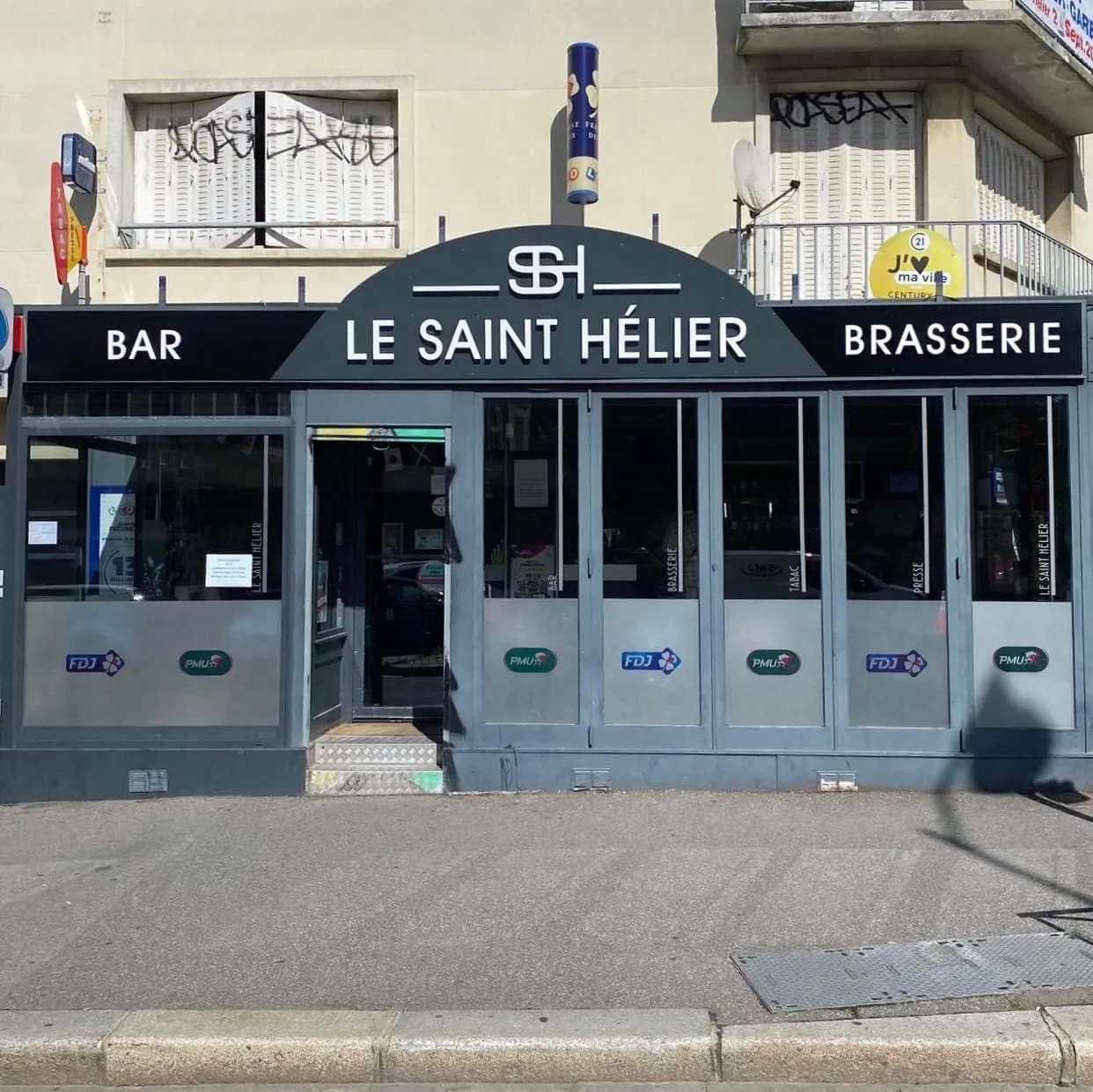Devanture du Saint-Hélier rue Saint-Hélier : auvent noir portant « Bar », « Le Saint-Hélier » et « Brasserie », vitrines marquées FDJ et PMU.