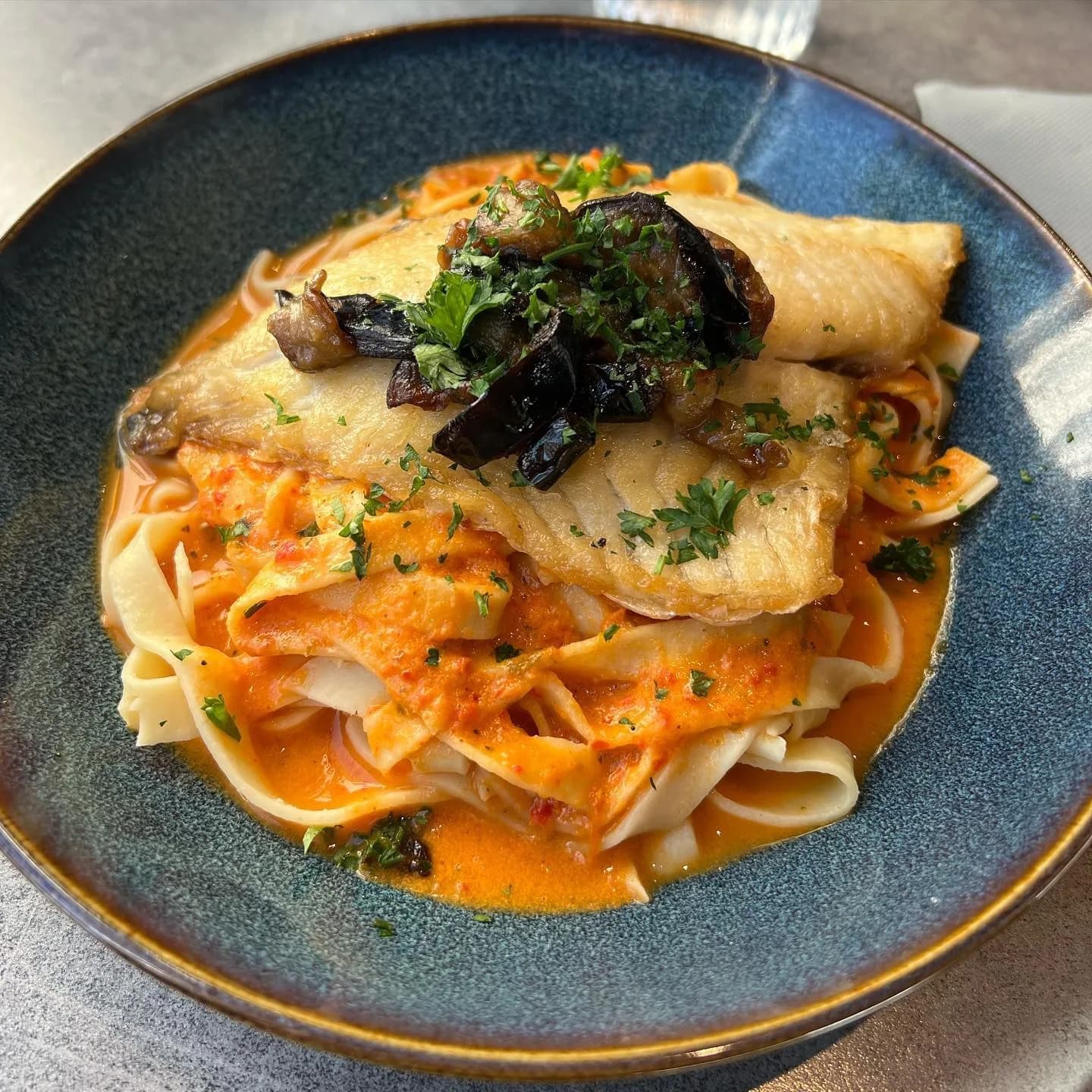 Un plat servi au Saint-Hélier : dos de poisson poêlé sur tagliatelles, sauce rouge et aubergines confites.